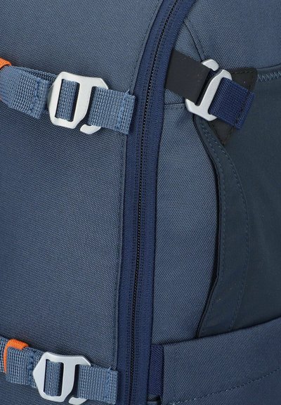 Zaino blu con tessuto testurizzato, zip e spallacci regolabili con dettagli in grigio e arancione.