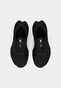 Mustade jooksutossude paar helkivate paelte ja pehmendatud tallaga, vaadates �ülevalt valgel taustal.