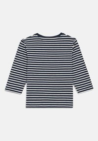 Námornícky modré a biele horizontálne pruhované tričko s dlhým rukávom a okrúhlym výstrihom, zobrazené zozadu na bielom pozadí.