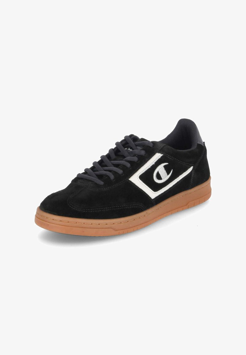Sneaker in suede nero con logo bianco, lacci grigi e suola in gomma. Il design presenta una punta arrotondata e una superficie liscia.