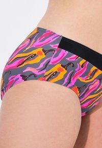 Slip bikini multicolore con un vivace motivo astratto nei toni di rosa, arancio e nero, dotato di una vita nera solida e di una texture morbida.