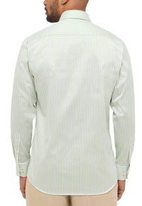 Camicia a maniche lunghe con vista posteriore caratterizzata da righe verticali verdi e bianche, colletto standard e polsini con bottoni. Tessuto con texture liscia.