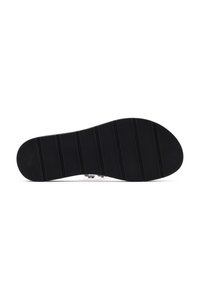 Semelle de chaussure en caoutchouc noir avec des rainures horizontales et une forme arrondie, présentant un bord lisse et une légère courbe au niveau de la zone des orteils.