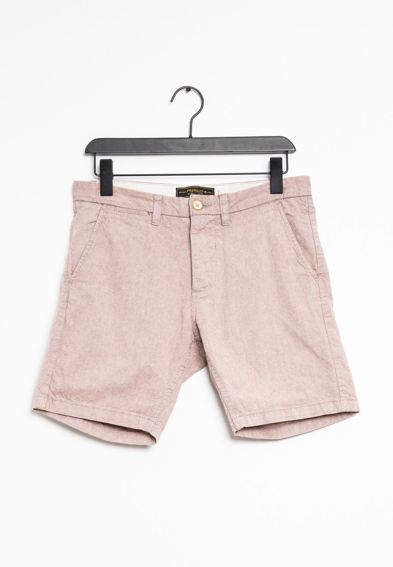 Shorts décontractés rose clair avec poches avant, passants de ceinture et fermeture à bouton, suspendus sur un cintre noir sur fond blanc.