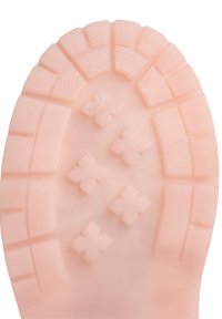 Suela de zapato de goma en rosa claro, con una superficie texturizada, bordes acanalados y patrones de tracción en forma de cruz para un mejor agarre.