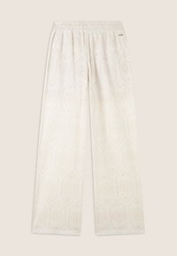 Pantaloni leggeri color crema con vita elasticizzata, caratterizzati da un motivo esagonale con piccole aperture e dettagli floreali in tutto il tessuto.