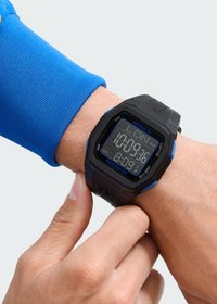 Skaitmeninis sportinis laikrodis su juodu ir mėlynu plastiku korpusu, apvalia forma, LCD ekranu ir guminiu dirželiu. Pagrindinės savybės: smūgiams atsparus ir laikmačio funkcijos.