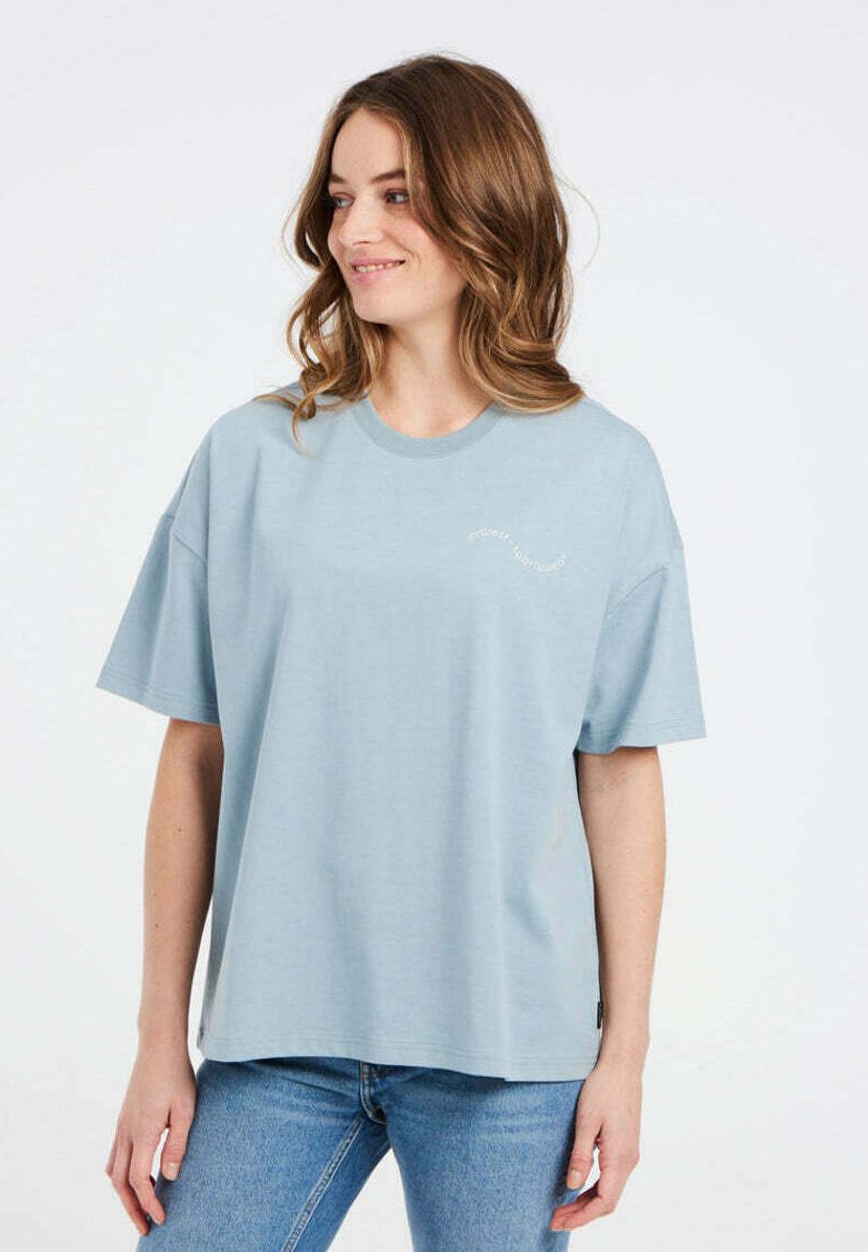 Lichtblauwe katoenen t-shirt met korte mouwen, ronde hals en subtiele tekstdetail op de voorkant. Relaxte pasvorm, soepele textuur.