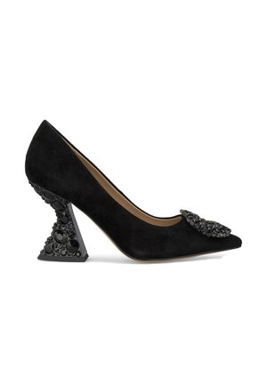 Schwarze Wildleder-Pumps mit hohen Absätzen, einer spitzen Zehenpartie, verziertem Schleifendetail und einem einzigartigen geometrischen Absatz, der mit schwarzen Edelsteinen geschmückt ist.