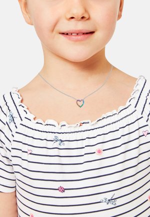 Collana d'argento con un pendente a forma di cuore decorato con pietre multicolori. Bambina che indossa una maglietta a righe bianche e blu navy con scollo a rouches.