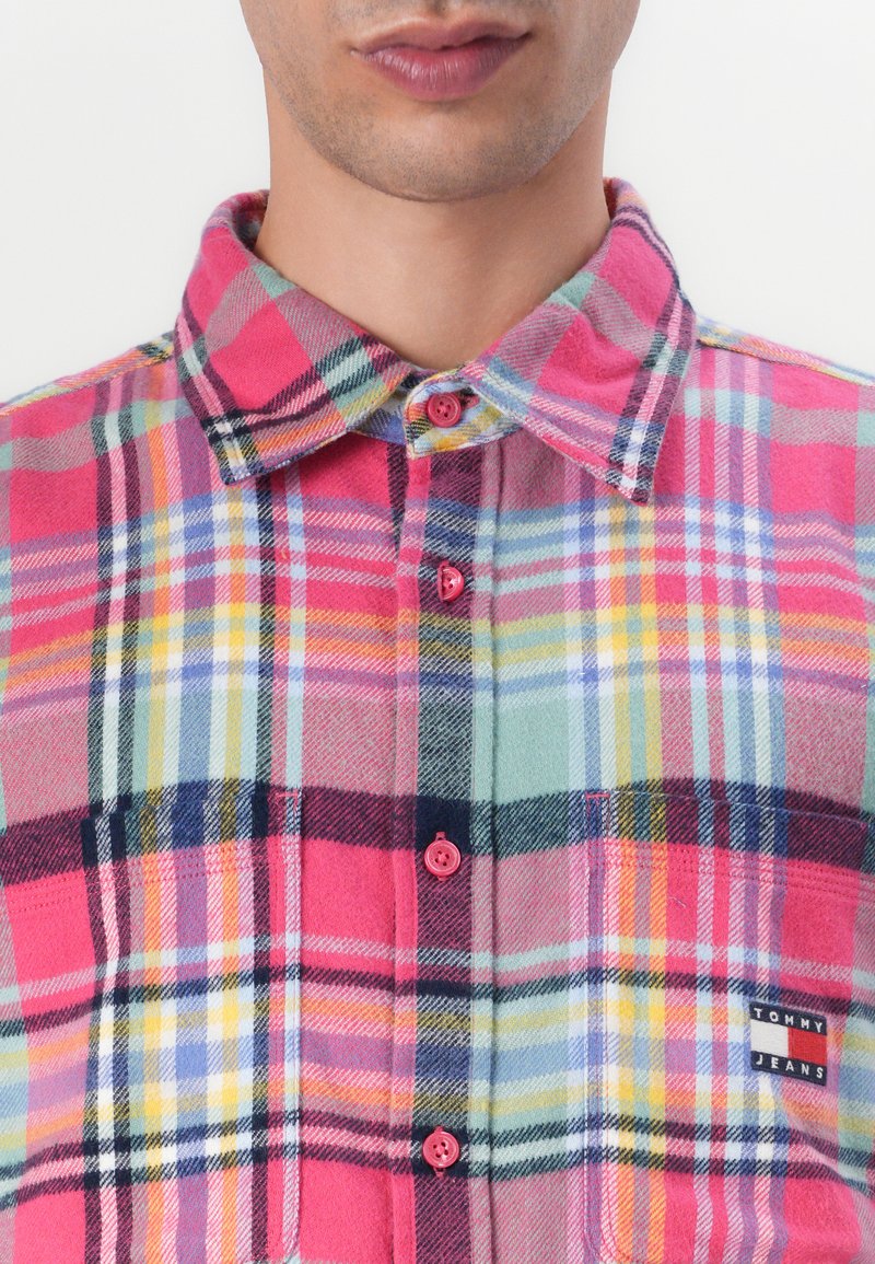 Roze en groene geruite flanellen overhemd met knoopsluiting aan de voorkant, ronde kraag, borstzak en logo patch. Voorzien van kleine roze knopen.