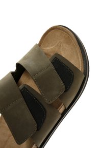 Sandali verde oliva con due fascette larghe, una in pelle e una in tessuto nero. Soletta in morbido suede marrone e suola nera texturizzata.