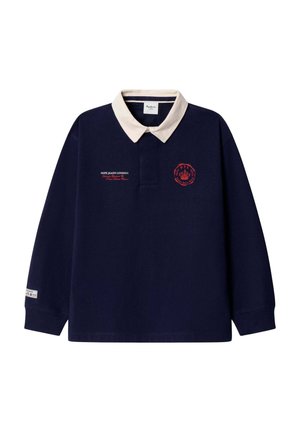 Marineblaues Poloshirt mit langen Ärmeln, weißem Kragen, rotem Logo auf der linken Brust, kleinem Text auf der rechten Brust und Label am linken Ärmelbündchen.