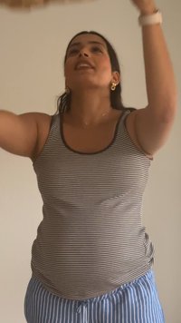 Ριγέ μπλουζάκι χωρίς μανίκια σε καφέ και λευκό χρώμα, συνδυασμένο με παντελόνι με ρίγες σε μπλε και λευκό. Το φόντο είναι απλό και ανοιχτόχρωμο.