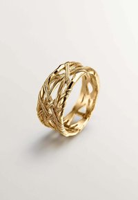 Anillo de oro con un intrincado diseño trenzado donde múltiples bandas se cruzan entre sí, creando un patrón texturizado y abierto.