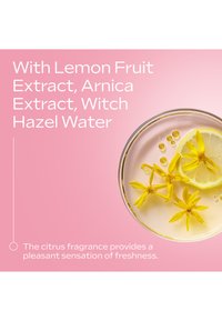 Liquido chiaro in un piatto rotondo con fetta di limone e fiori gialli, su uno sfondo rosa con testo sugli estratti naturali.