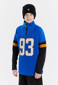 Niebieski siatkowy pulower sportowy z pomarańczowymi i czarnymi akcentami, z wysokim kołnierzem i wyraźnie wyeksponowaną liczbą 93 w kolorze białym.