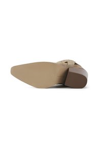 Beige suede shoe sole with a rounded toe and a block heel. The sole features horizontal ridges for traction and an embossed size mark.