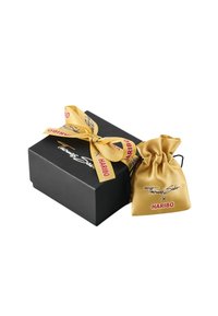 Boîte cadeau noire avec un ruban doré et une étiquette ; pochette à cordon en satin doré. "Thomas Sabo x HARIBO" imprimé en noir et rouge.
