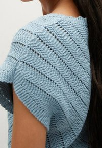 Lichtblauw gehaakt topje met een gestructureerd, open steekpatroon, korte mouwen en een ronde hals.