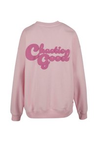Rosa hettegenser med lange ermer, ribbestrikkede mansjetter og kant. Stort "Chaotic Good"-grafikk i en mørkere rosa på baksiden. Myk stofftekstur.
