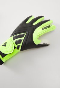 Goalkeeper glove featuring a black palm, bright neon yellow textile back, textured grip, and adjustable strap with "adidas" branding.