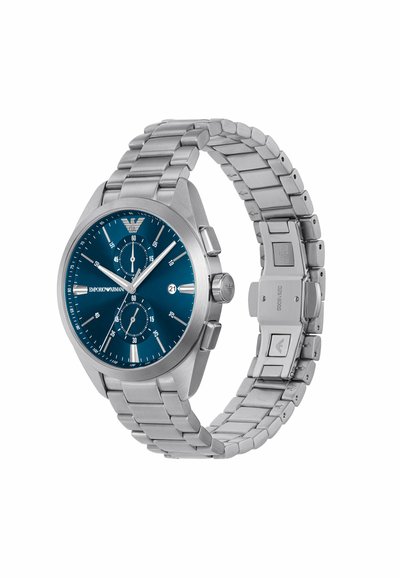 Montre en acier inoxydable avec un cadran bleu, des index horaires en argent, des sous-cadrans chronographes, et un bracelet en métal avec une boucle de sécurité.
