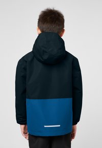 Waterproof jacket with a black upper section and a blue lower section. Features a hood and a reflective strip on the back hem.