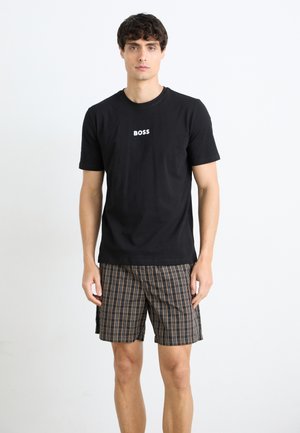 Schwarzes Baumwoll-T-Shirt mit weißem "BOSS"-Logo, kombiniert mit braunem kariertem Shorts mit mehreren Farben und einem lockeren Schnitt.