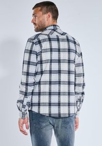 Karierte Hemd mit langen Ärmeln, aus gewebtem Stoff in grau, weiß und marineblau. Verfügt über einen klassischen Kragen und Knopfmanschetten, mit einem abgerundeten Saum.