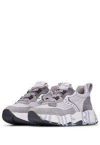 Graue Sneaker mit einer Mischung aus Texturen, einschließlich Netzgewebe und Wildleder, mit einer voluminösen Sohle und markanter weißer Branding auf der Sohle.