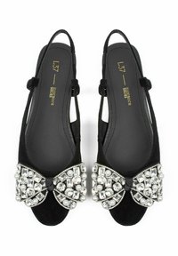 Black suede slingback shoes featuring a jeweled bow with clear and pearl accents, open toe design, and adjustable ankle straps.