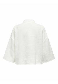 Blouse blanche texturée à manches longues avec manches larges et ourlet droit, vue de dos sur un fond uni.