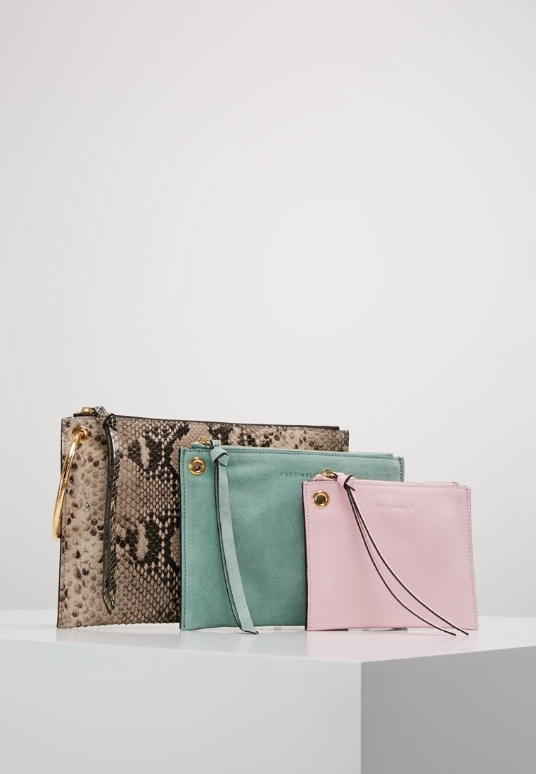 Tre pochette con cerniera di dimensioni diverse: una in stampa serpente con accentatura dorata, una in suede verde e una in pelle rosa con bordi neri.