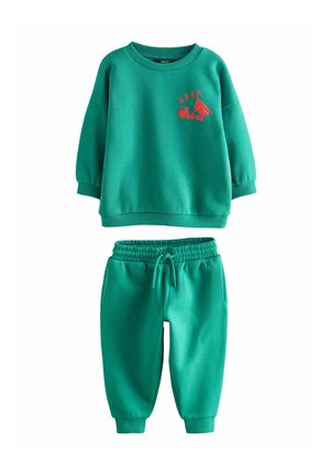 Conjunto de sudadera de algodón verde y pants a juego, que presenta un gráfico de tren rojo en la sudadera y una cinturilla elástica en los pantalones.