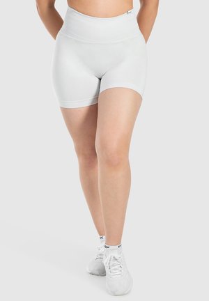 Lichtgrijze high-waisted sportshorts met een aansluitend ontwerp, gladde textuur en geribde tailleband. Gecombineerd met witte sportschoenen en sokken.