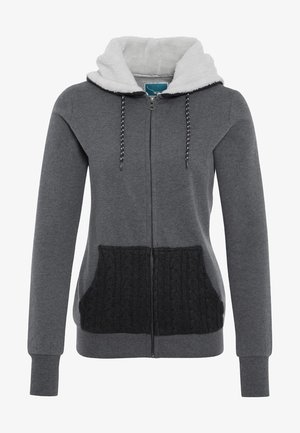Felpa grigia con zip, dotata di un cappuccio morbido foderato in bianco pile, tasche a maglia nera e coulisse a contrasto. Presenta maniche lunghe e una cerniera frontale.