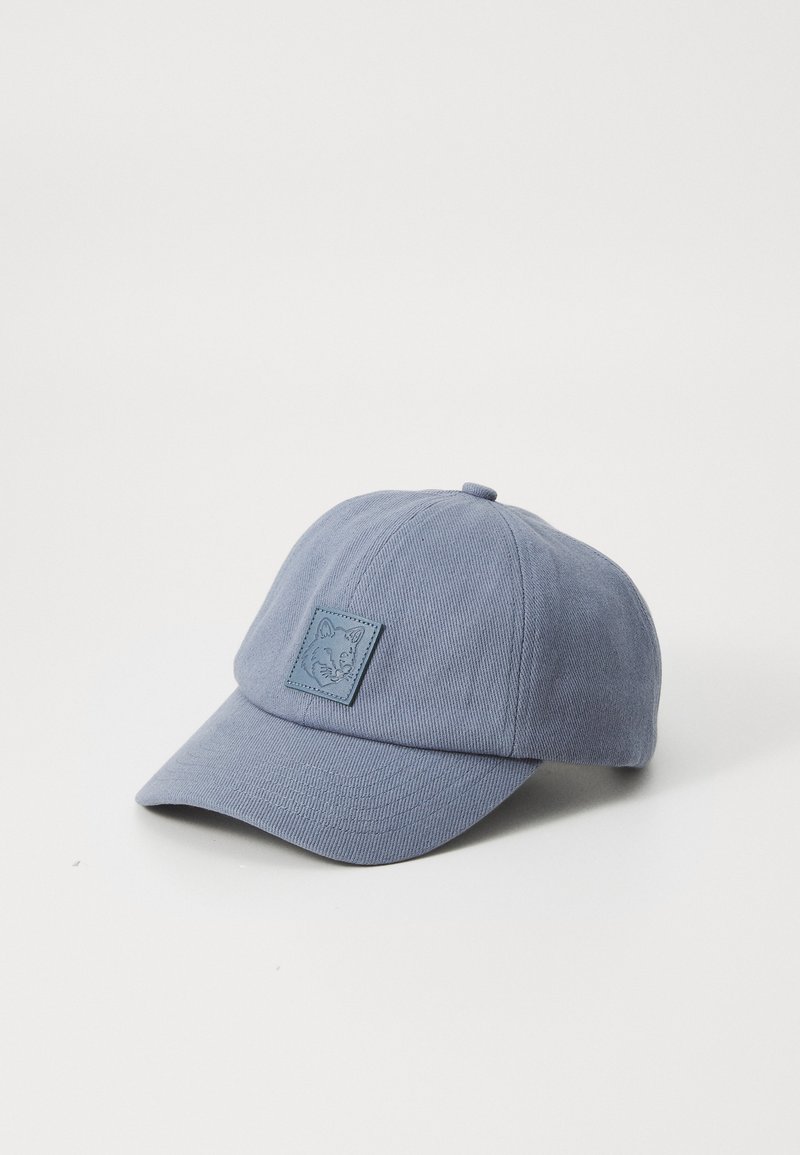 Casquette de baseball en coton bleu avec une surface texturée, visière courbée et un patch carré avec un design en relief à l'avant.