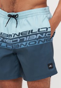 Shorts de bain pour hommes en bleu clair et bleu marine foncé, avec un imprimé logo O'Neill contrastant et une taille élastique avec cordon de serrage.