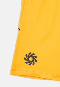 Gul atletisk tröja med en mörkblå spiral-logotyp vid fållen, nätstruktur på sidorna och en slät, enfärgad tyg genom hela tröjan.