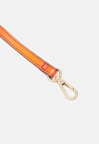 Kirkkaan oranssi nahkaranneke, jossa on kontrastiväriset mustat ompeleet ja päässä kultainen metallinen kiinnike. Ranneke on sileäpintainen ja tukevarakenteinen.