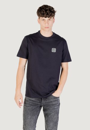 Mørkeblå bomulds T-shirt med korte ærmer og rund halsudskæring, der har et lille logo-patch på venstre bryst og en afslappet pasform.