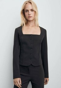 Blazer nero aderente a maniche lunghe con scollo quadrato, caratterizzato da una fila di sei bottoni e un tessuto liscio e testurizzato.