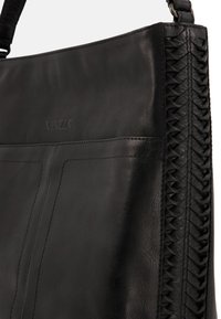 Black leather handbag with woven detailing along the side, featuring a smooth texture and subtle embossed logo. Simple, functional design.