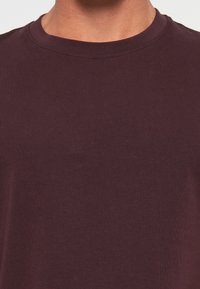 Bordeaux crewneck t-shirt van katoen, met een gladde textuur en korte mouwen in een eenvoudige uitvoering.