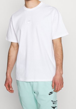 Weißes Baumwoll-T-Shirt mit kurzen Ärmeln, ausgestattet mit einem kleinen, gestickten Nike-Logo auf der Brust. Schlichtes, klassisches Design.