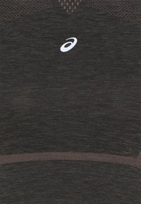 Maglietta sportiva grigio scuro con motivi testurizzati e inserti in rete. Presenta un logo bianco al centro. Tessuto morbido, vestibilità aderente.