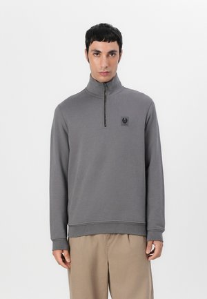 Gray zippered sweatshirt with a high collar, featuring a small black logo on the chest and ribbed cuffs. Soft fabric with a smooth texture.