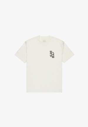 Witte katoenen t-shirt met een ronde hals en korte mouwen. Heeft een zwart grafisch logo op de linkerborst. Soepele textuur, casual pasvorm.