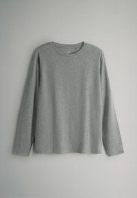 Pilkas ilgomis rankovėmis marškinys, pagamintas iš minkštos medvilnės mišinio, su apvaliu kaklu ir atsipalaidavusiu siluetu. Lygus paviršius be matomų raštų ar akcentų.